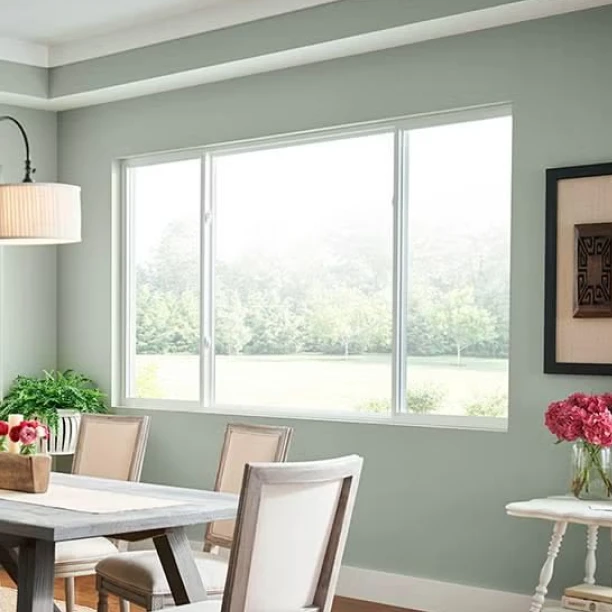 Dining area with large picture window providing natural light and outdoor garden view